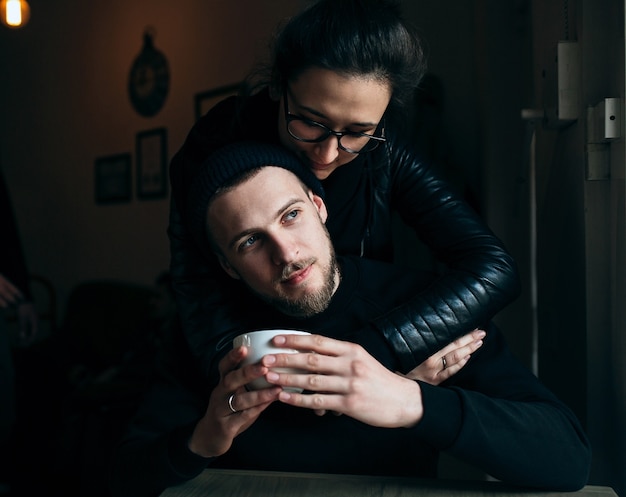 Femme embrassant son petit ami en buvant du café