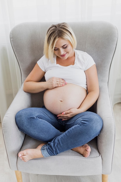 Femme enceinte à angle élevé sentant son enfant