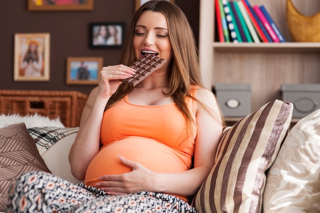 Femme enceinte appréciant de manger du chocolat