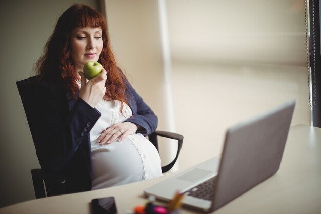 Femme enceinte ayant une pomme