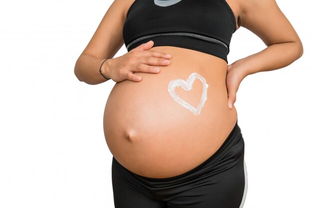 Femme enceinte avec un coeur dessiné sur le ventre
