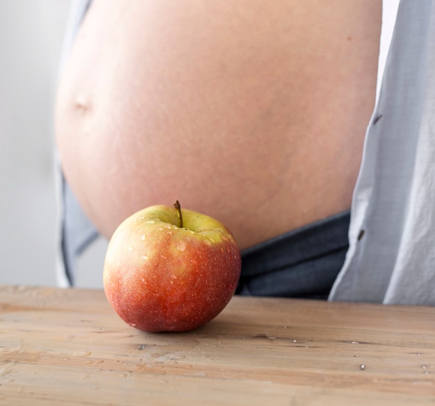 Femme enceinte à côté de pomme sur la table close-up