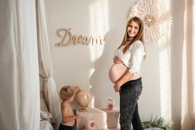 Femme enceinte debout avec son fils dans une pièce à l'intérieur