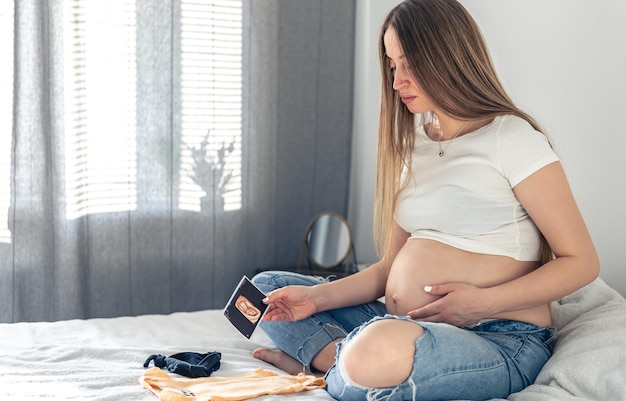 Photo gratuite une femme enceinte avec une image échographique du concept de grossesse infantile