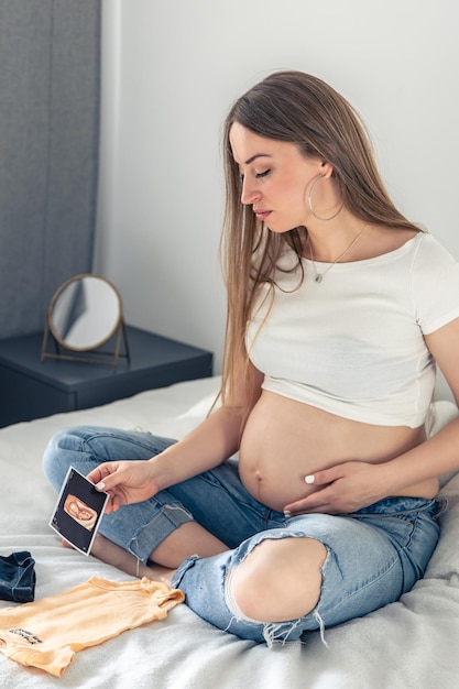 Une femme enceinte avec une image échographique du concept de grossesse infantile