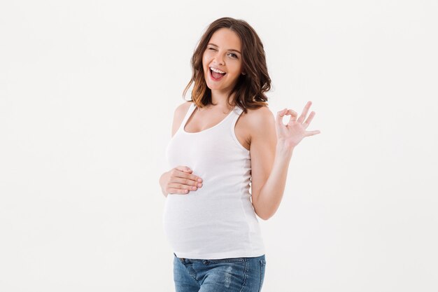 Femme enceinte joyeuse montrant un geste correct.
