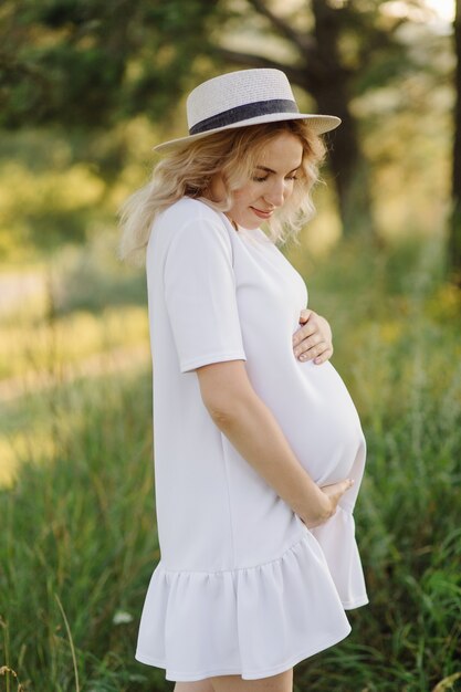 Femme enceinte, marche, dans parc, à, coucher soleil