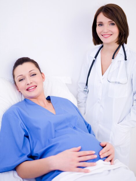 Femme enceinte avec médecin à l'hôpital de maternité avant l'accouchement