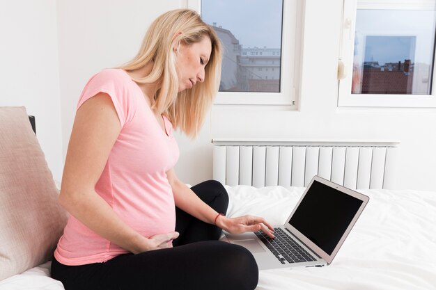 Femme enceinte avec un ordinateur portable