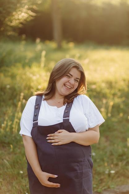 Femme enceinte posant dans le parc