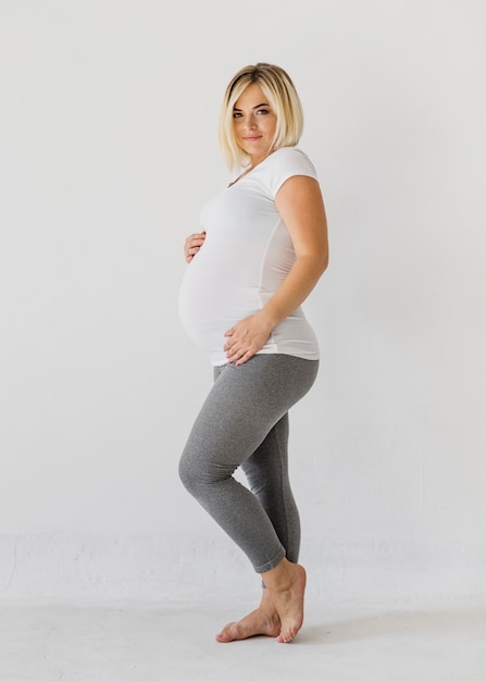 Femme enceinte posant en regardant la caméra