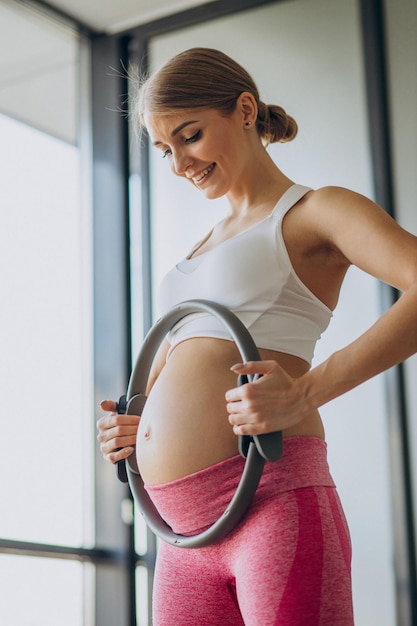 Femme enceinte pratiquant le yoga à la maison