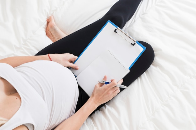 Femme enceinte en regardant le presse-papiers