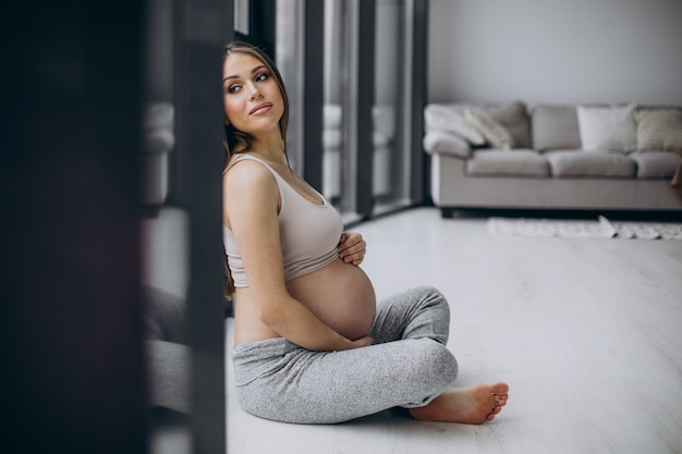 Femme enceinte se reposant après l'exercice à la maison