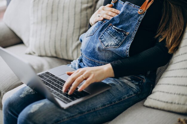 Femme enceinte utilisant un ordinateur à la maison