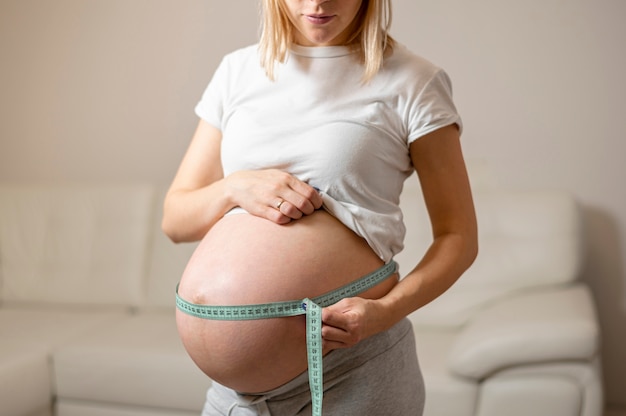 Femme enceinte vue de face mesurant son ventre