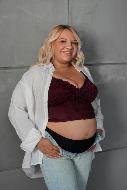 Photo gratuite femme enceinte vue de face qui pose en studio