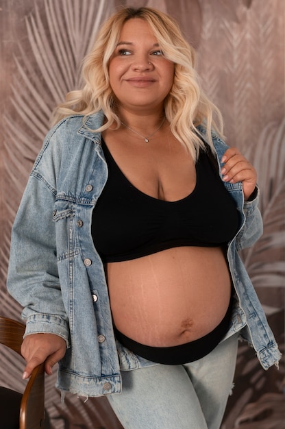 Photo gratuite femme enceinte vue de face qui pose en studio