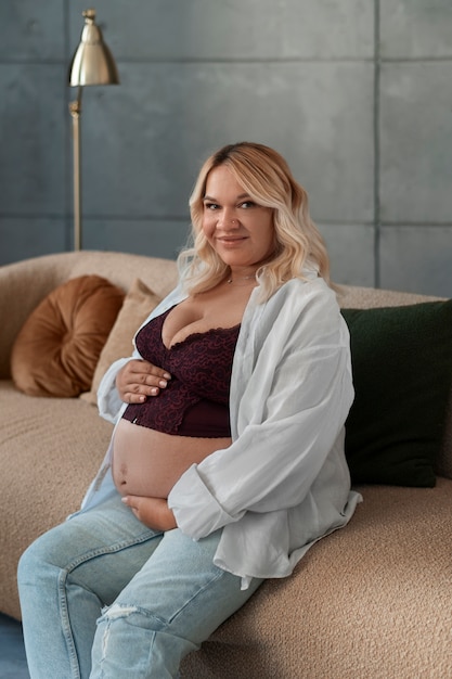 Photo gratuite femme enceinte vue latérale qui pose en studio