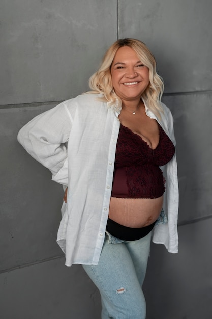 Photo gratuite femme enceinte vue latérale qui pose en studio