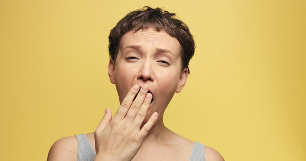 Femme endormie des années 30 avec une coupe de cheveux courte sur un fond jaune d'atmosphère de matin