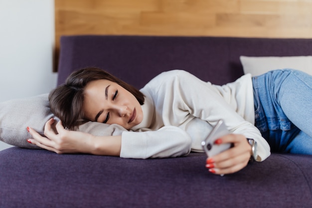 Femme endormie rêve sur le lit après une dure journée de travail