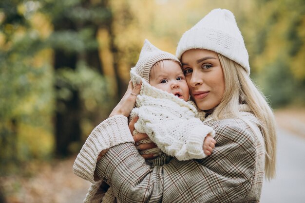 Femme avec enfant en bas âge dans le parc d'automne