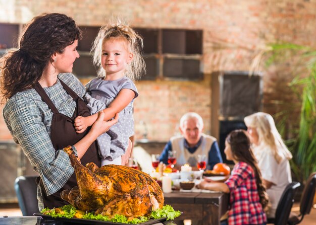 Femme avec enfant près de jambon rôti