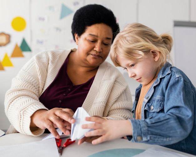 Femme enseignant à son élève l'origami