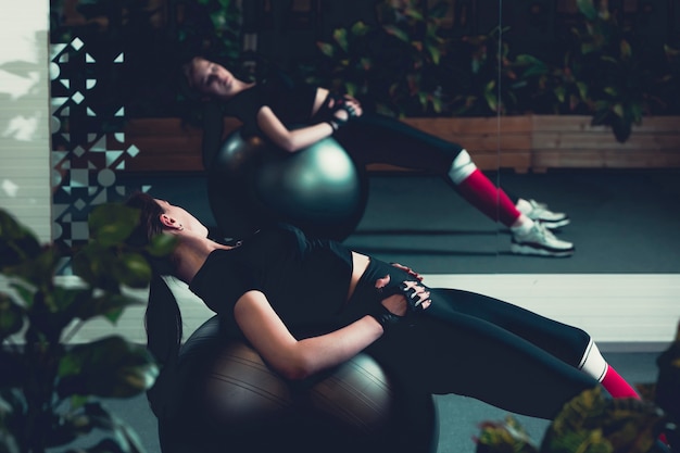 Femme entraînement avec ballon de gymnastique dans un centre de fitness