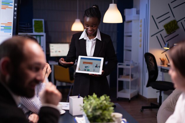 Femme entrepreneur surmenée dans la salle de réunion du bureau de l'entreprise expliquant la stratégie de gestion à l'aide d'une tablette