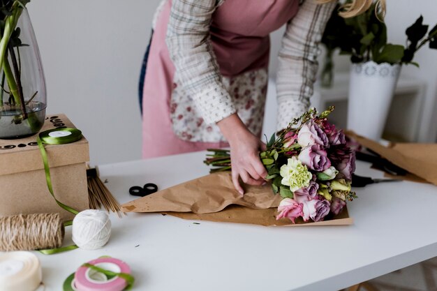 Femme enveloppant et arrangeant le bouquet