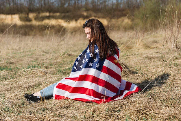 Femme Enveloppant Dans Le Drapeau Des Etats-unis Le 4 Juillet