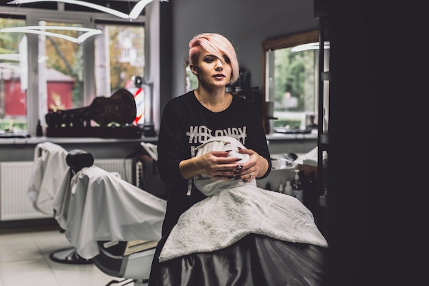 Femme enveloppant le visage du client dans le salon de coiffure