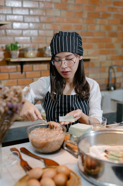 Photo gratuite femme enveloppée dans des boulettes cuisinier de cuisine asiatique.