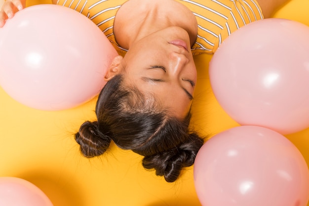 Photo gratuite femme à l'envers entourée de ballons