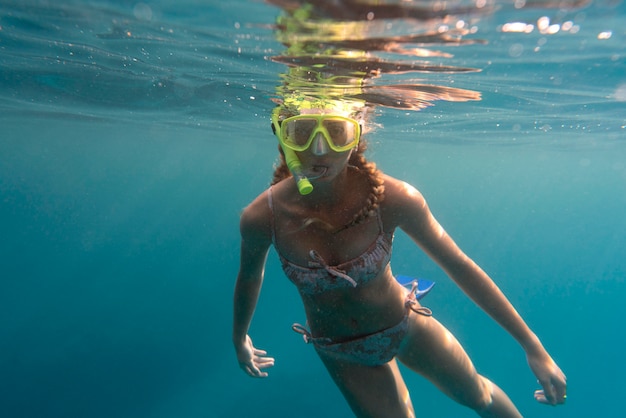 Femme avec équipement de plongée nager dans l'océan