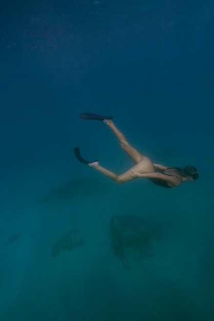 Femme avec équipement de plongée nager dans l'océan