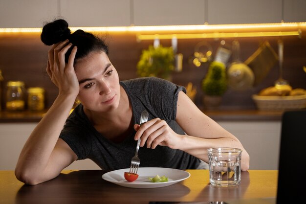 Femme essayant de manger sainement à la maison