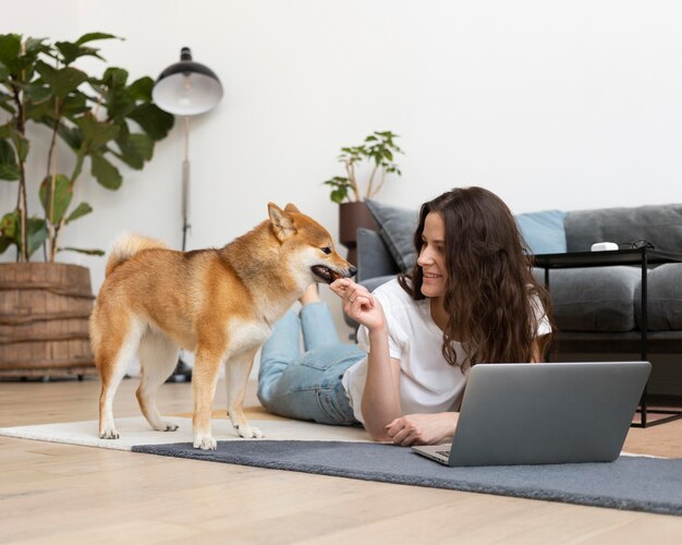 Femme essayant de travailler avec son chien autour