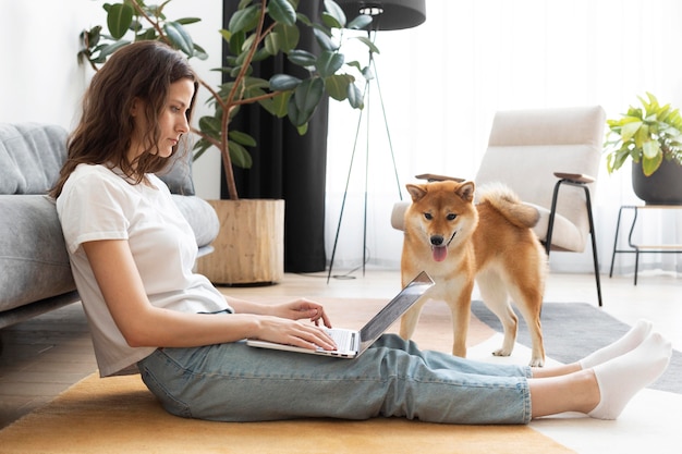 Femme essayant de travailler avec son chien autour