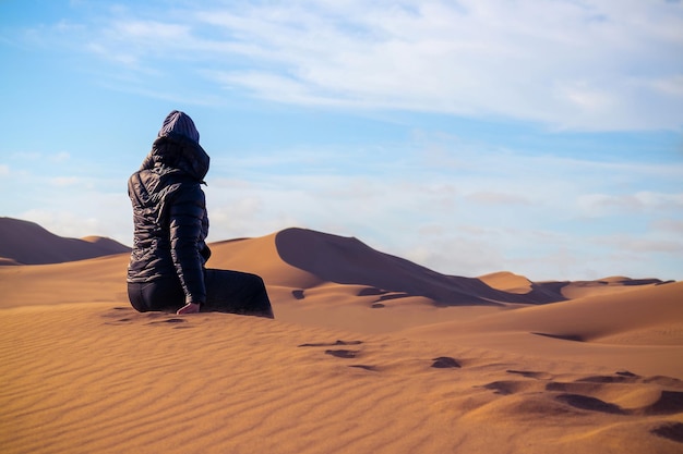 Une femme est assise sur la dune de sable doré du désert du namib. afrique