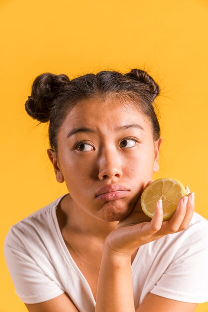 Femme étant bouleversée et tenant un citron