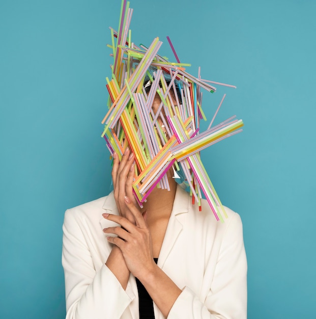 Photo gratuite femme étant couverte de pailles en plastique colorées