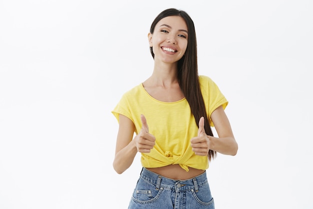 Femme étant ravie et heureuse, elle écoute les conseils d'un ami montrant les pouces vers le haut et souriant satisfait