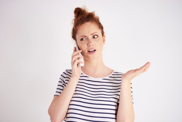 Femme étonnée parlant par coup de téléphone portable