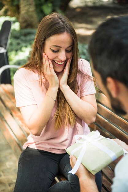 Femme étonnée regardant le cadeau de la Saint-Valentin acheté par son petit ami