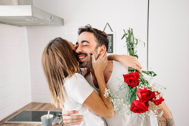 Femme étreignant l&#39;homme après avoir reçu le bouquet