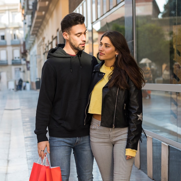 Femme étreignant jeune homme avec des paquets