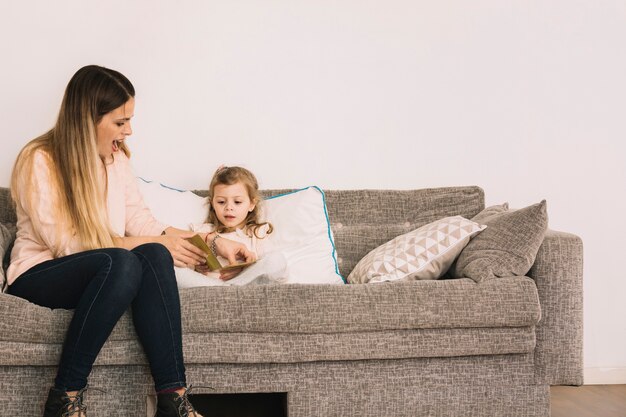 Femme excitée aidant sa fille à lire